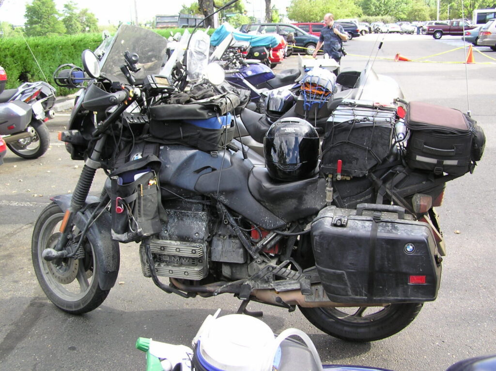 A mud-streaked BMW touring motorcycle loaded with luggage, a fuel cell and extra instruments after eleven days on the road.