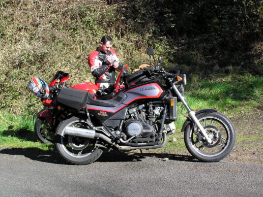 Red sport-tourer by the trees